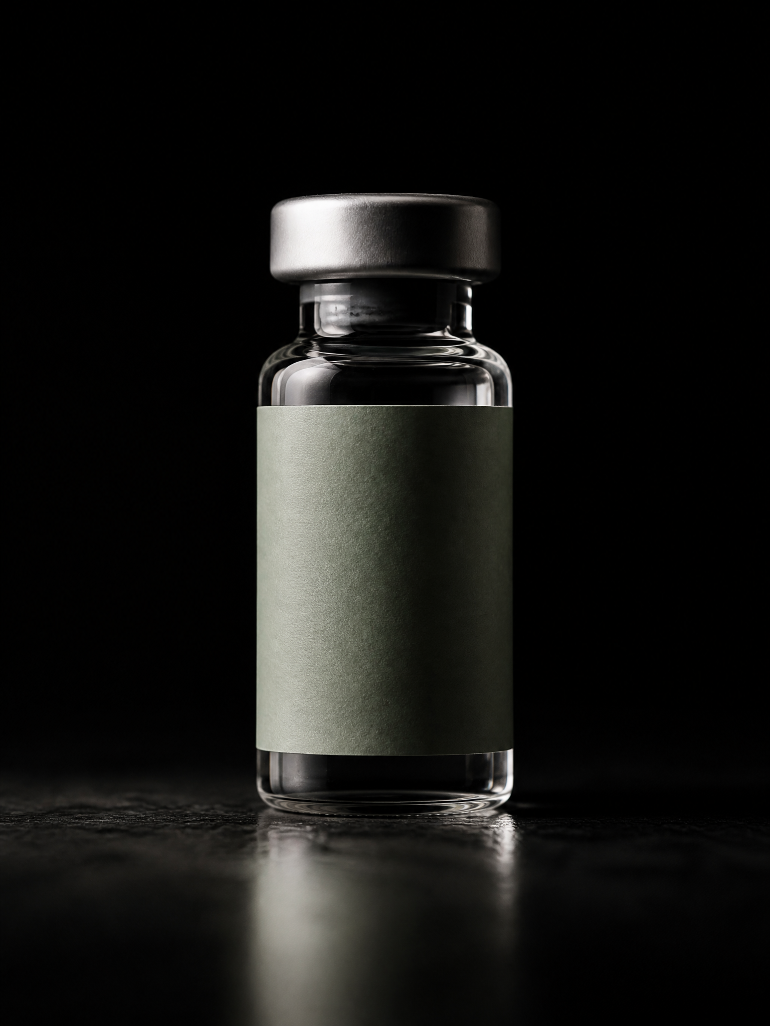 A single clear peptide vial with a silver cap under dramatic single-source light